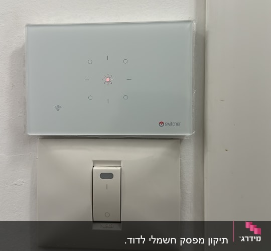 מתג חכם ומפסק חשמל על קיר לבן